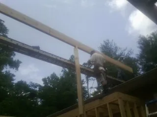 Carpenter setting a ridge beam over a new addition frame — Ice Dam Removal by Roofing Brothers in Primm Springs