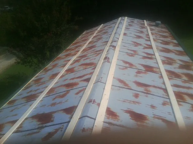 Rusted metal roof panels with new wood purlins before replacement — Storm Damage Roof Repair in Primm Springs by Roofing Brothers