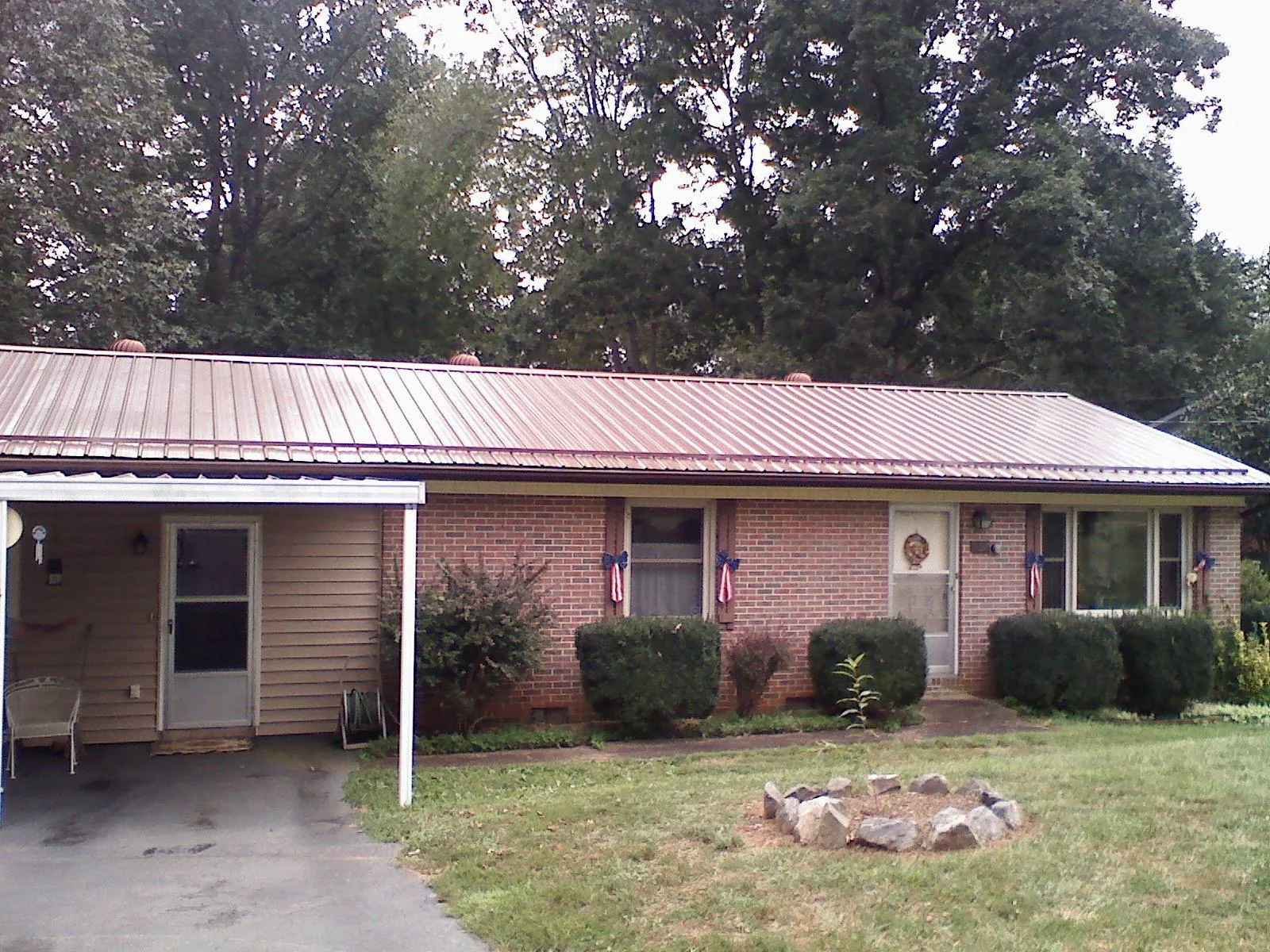 Bronze metal roof and carport on a brick ranch home — Roof Repair work by our crew in Primm Springs